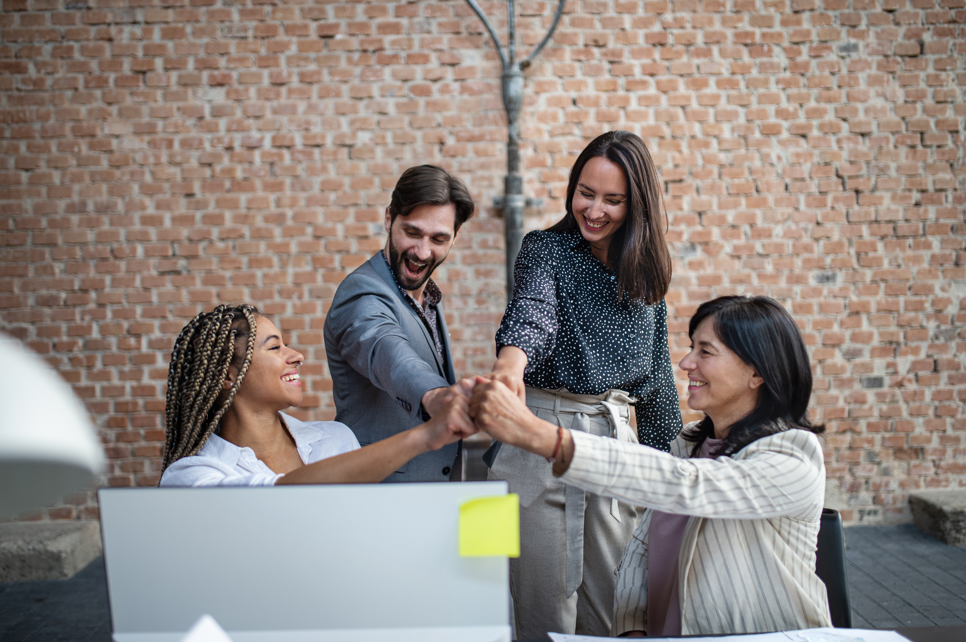 Cheerful Young and Old Businesspeople Celebrating Success in Office, Cooperation Concept.