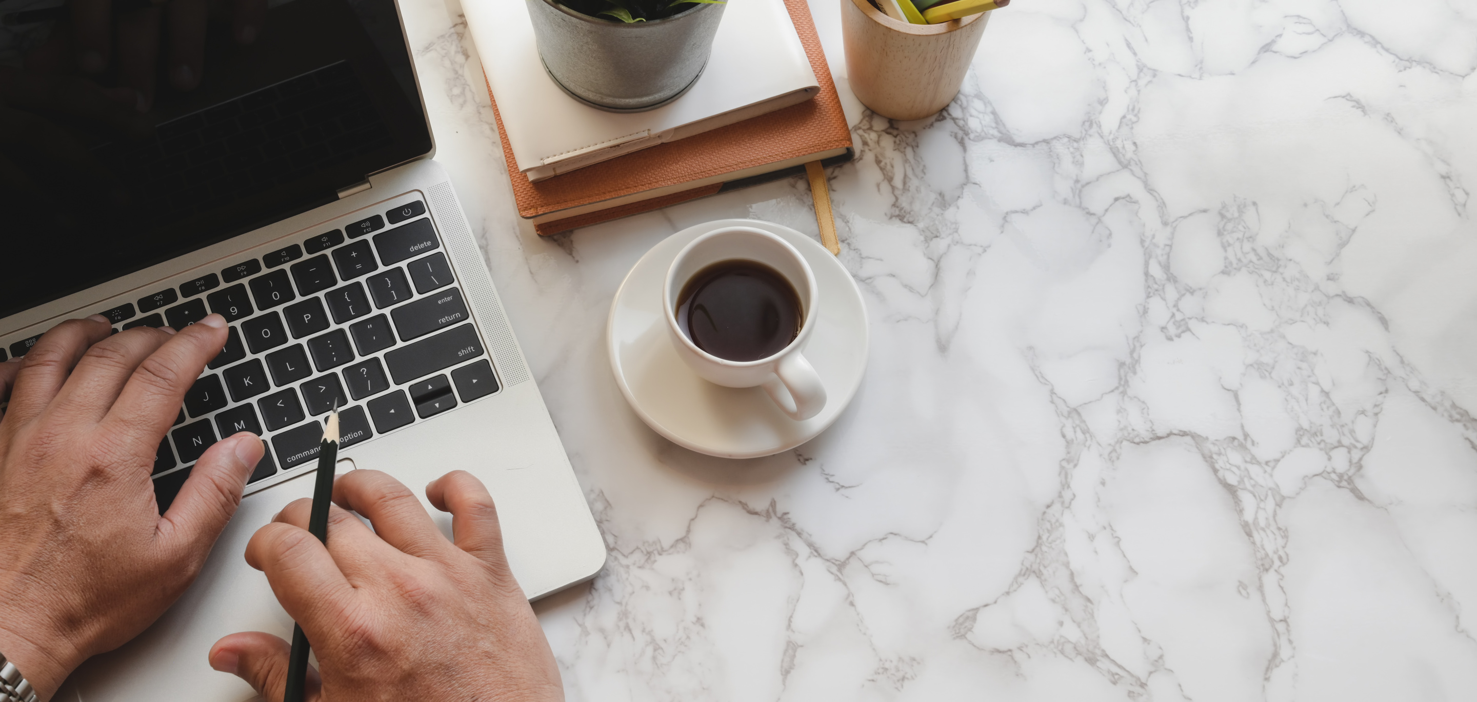 Anonymous man working on laptop having coffee